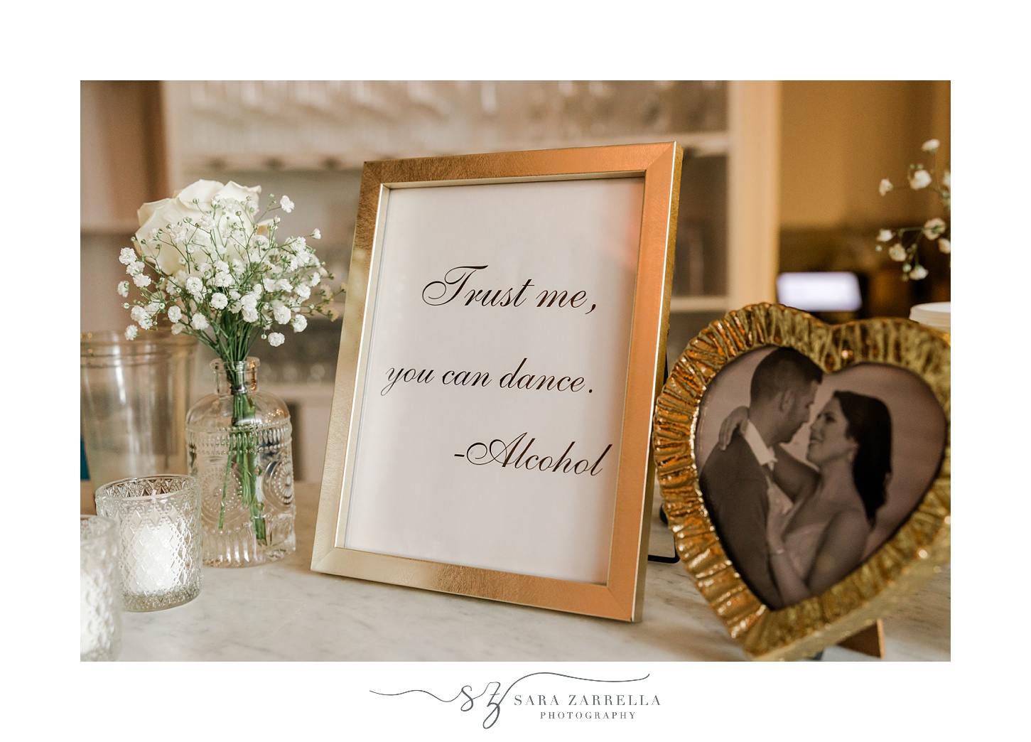 sign with gold frame by white baby's breath 