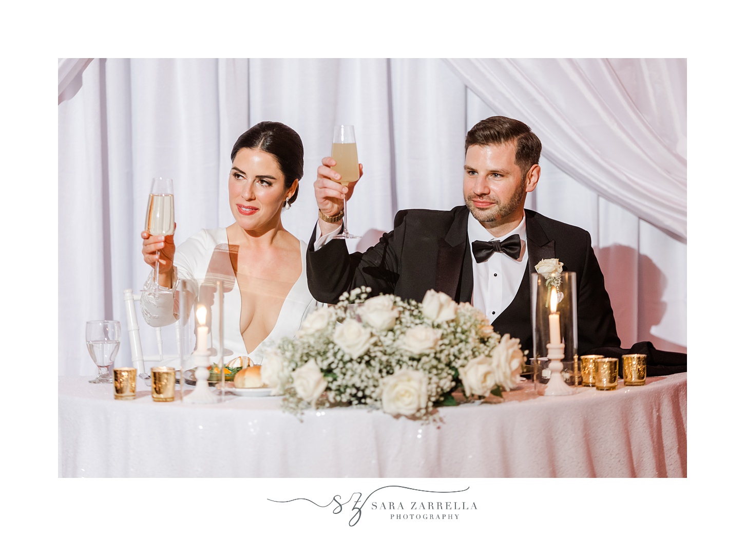 bride and groom lift glasses of champagne during New Year's Eve wedding reception at the Providence G