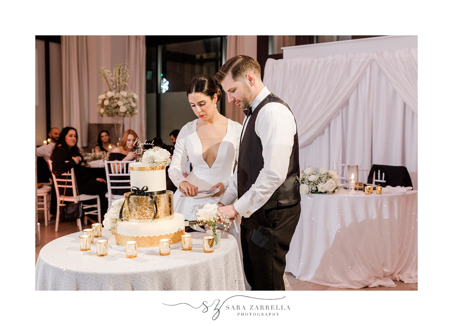 bride and groom cut wedding cake during New Year's Eve wedding reception at the Providence G