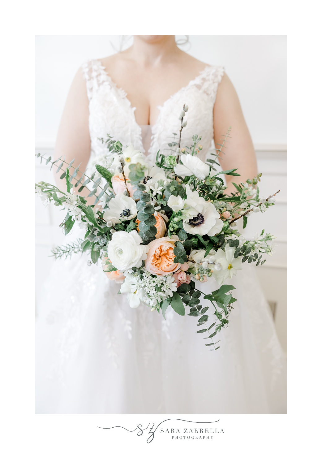 bride holds bouquet of white and peach flowers for spring wedding 