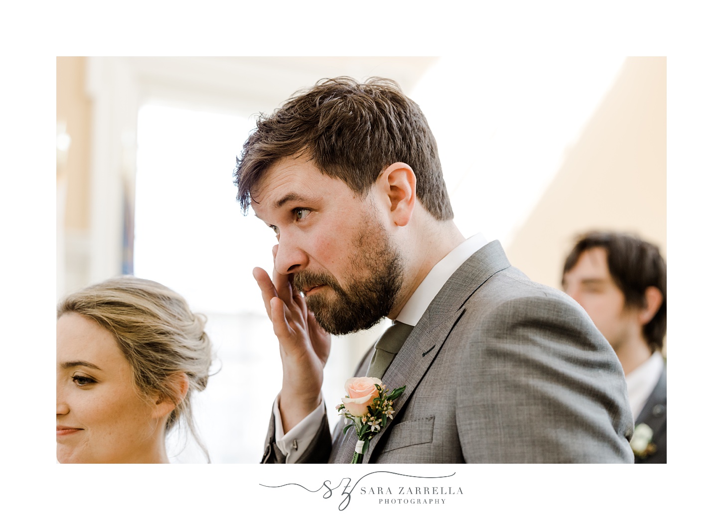 groom wipes away tear during ceremony in town hall