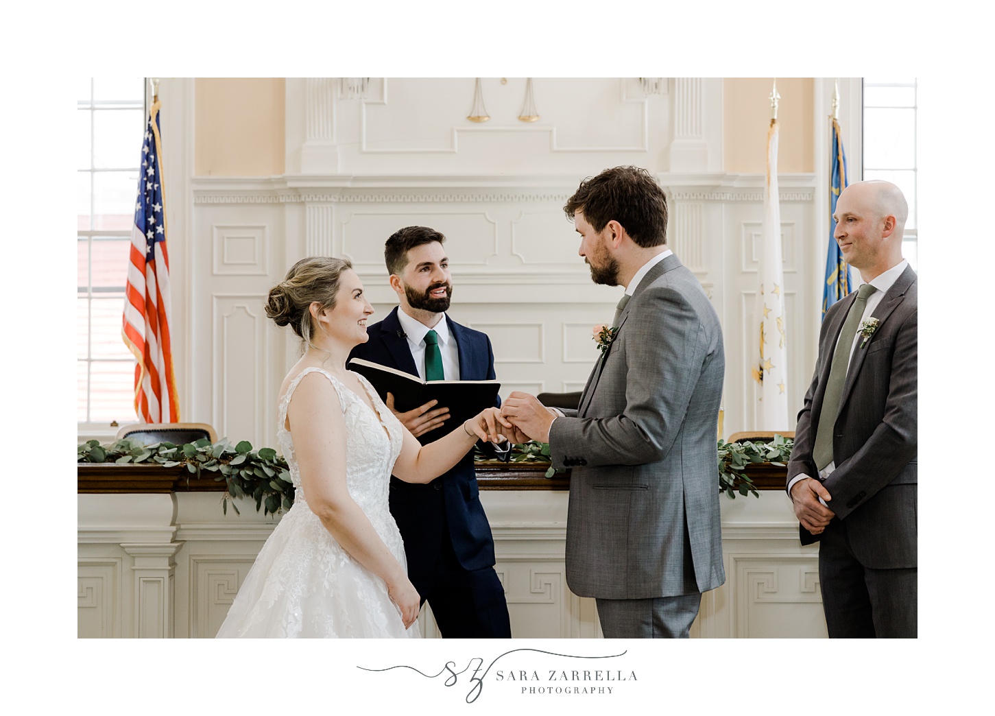 groom puts ring on bride's finger during East Greenwich Town Hall ceremony 