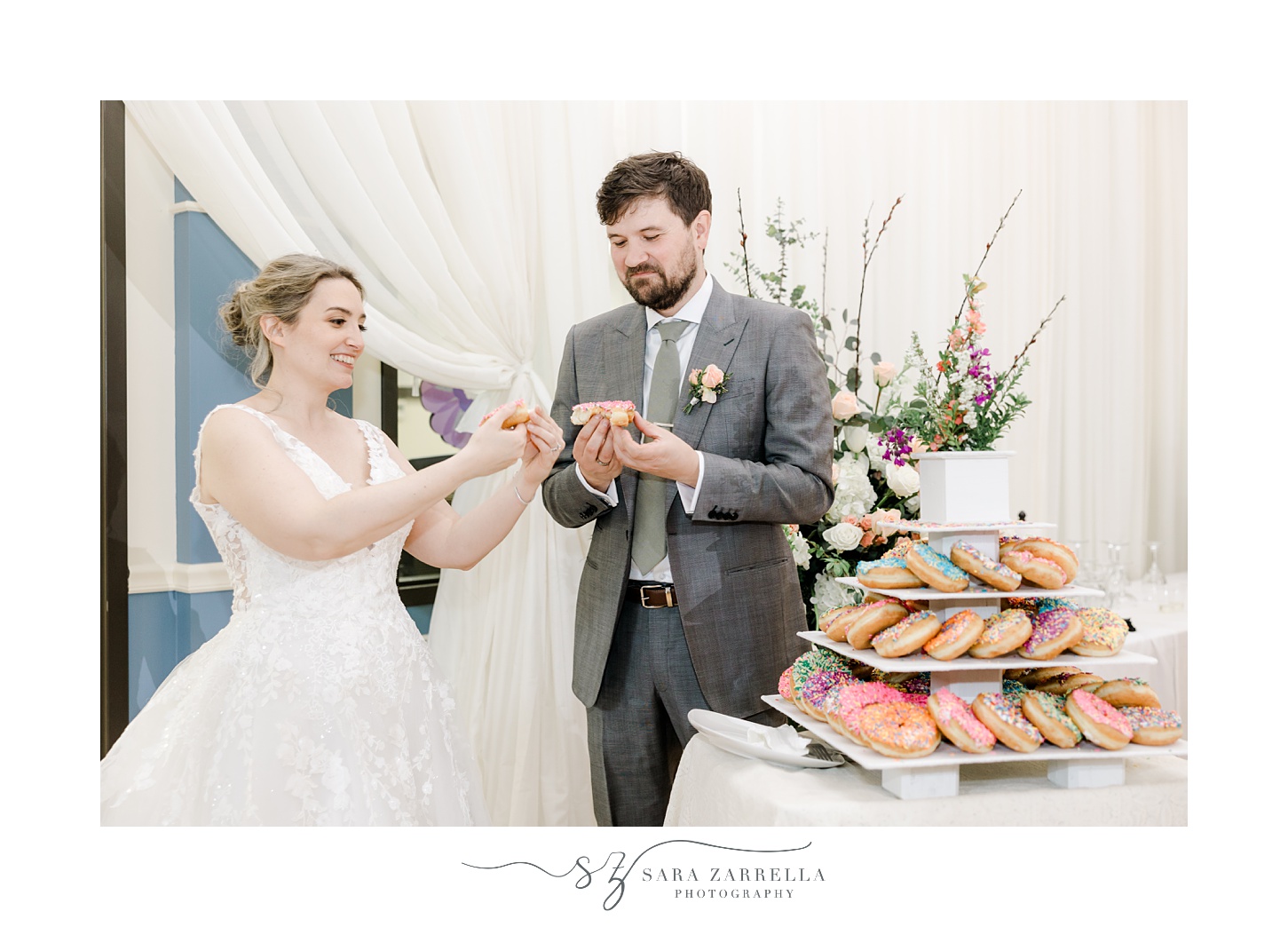 bride and groom share donuts during wedding reception 