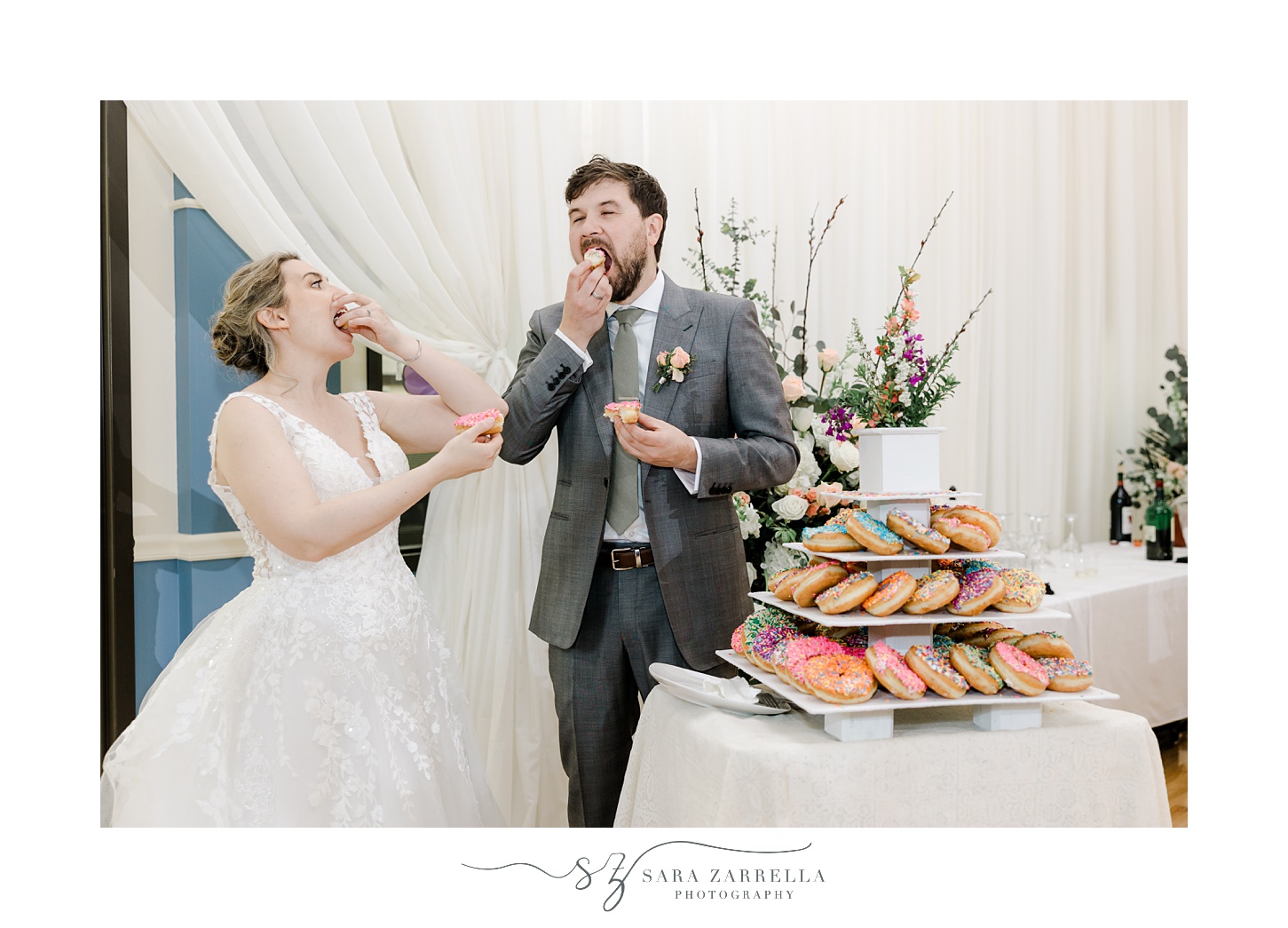 bride and groom share donuts during wedding reception 