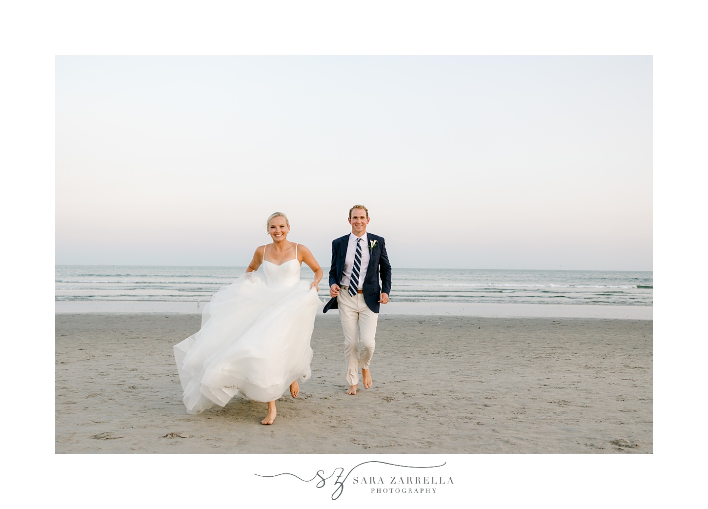 bride and groom hold hands running on the beach at Narragansett Bay