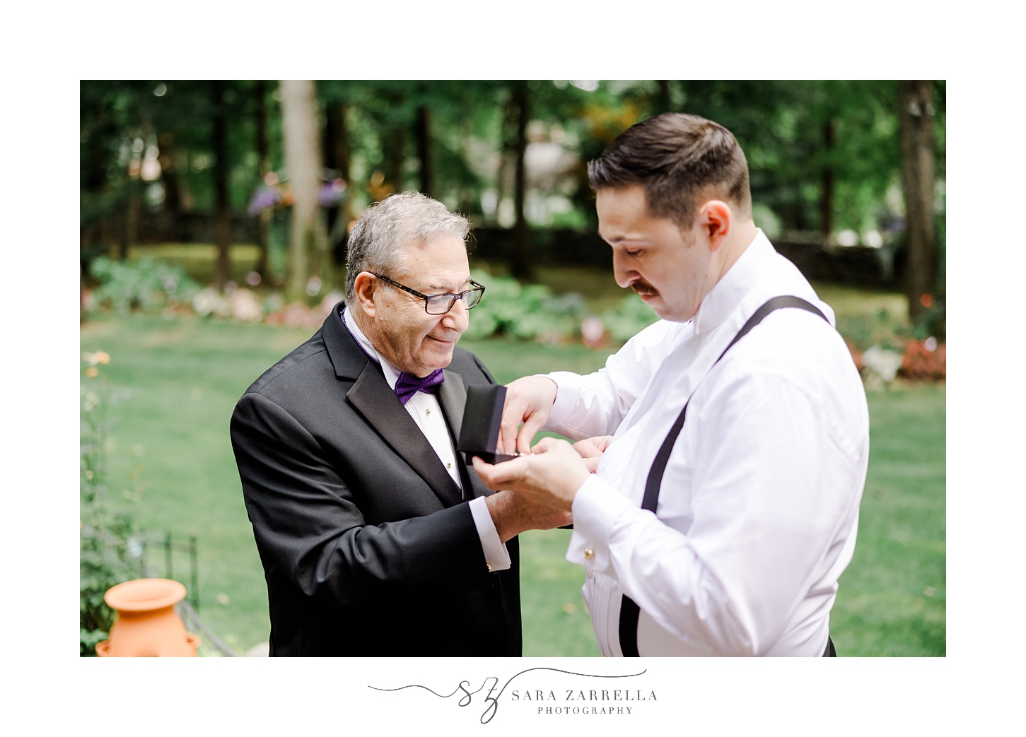 father adjusts cufflinks for groom before Rhode Island wedding