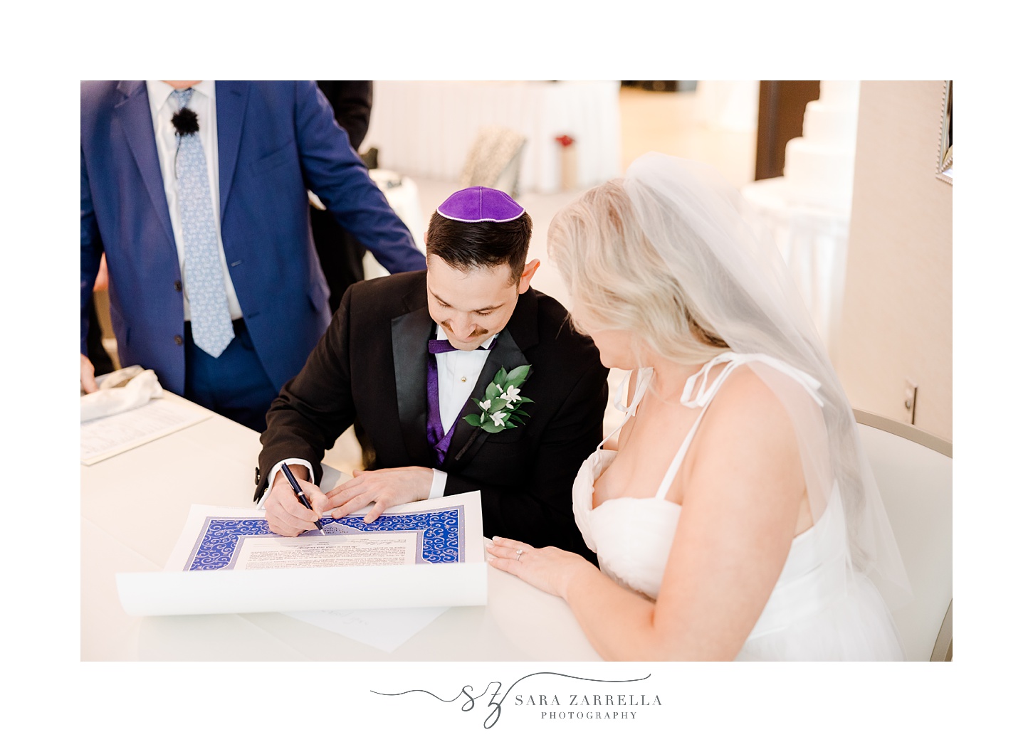 groom and bride sign ketubah on wedding day in Rhode Island