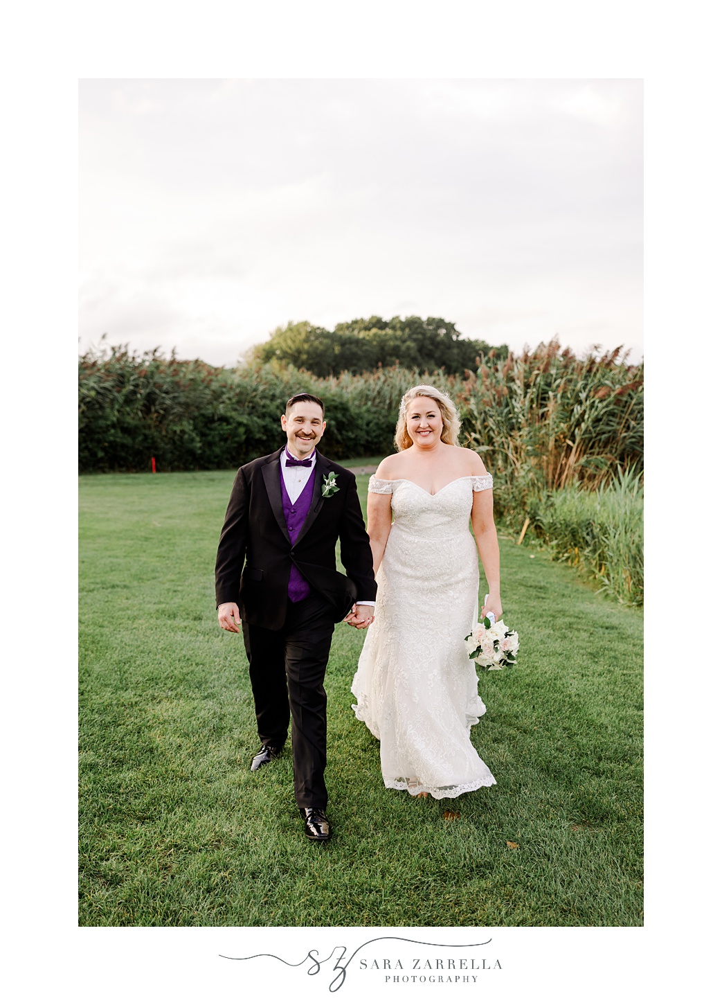 bride and groom hold hands walking on lawn at Quidnessett Country Club