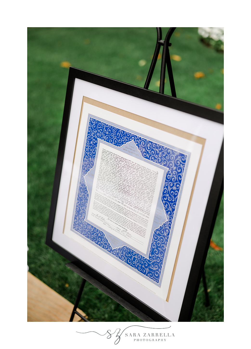 signed ketubah on display for Jewish wedding ceremony on the lawn at Quidnessett Country Club