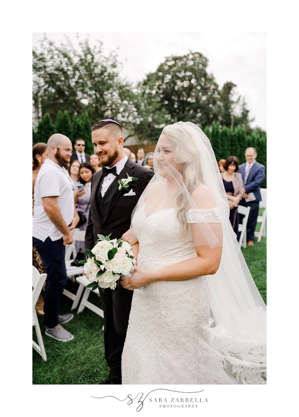 man escorts bride down the aisle during wedding ceremony