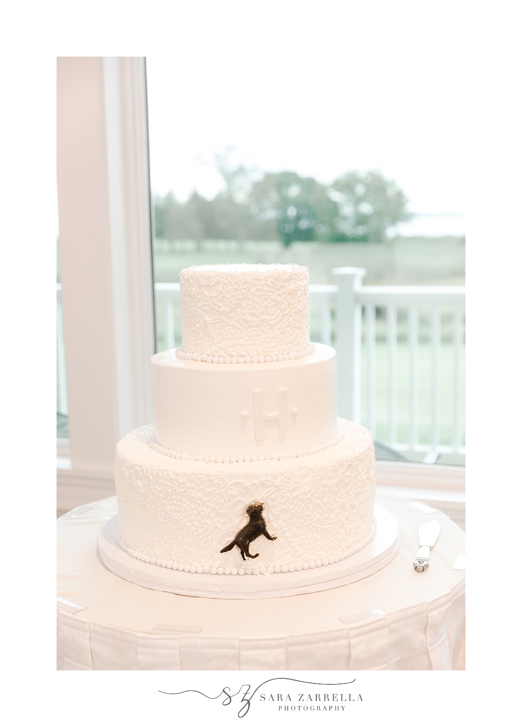 tiered wedding cake with black lab made of sugar on the bottom tier