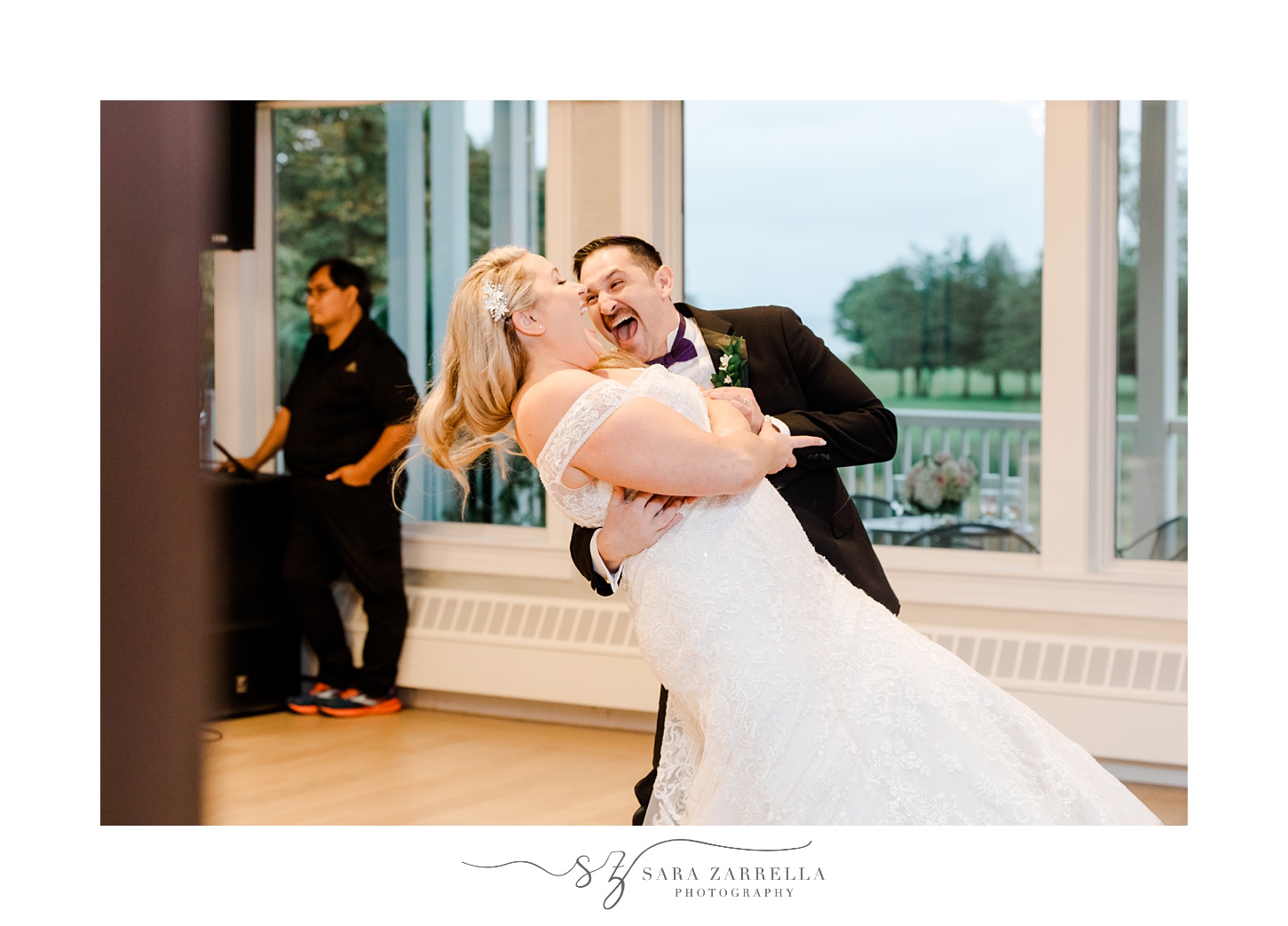 groom grins at bride dipping her during first dance at Quidnessett Country Club