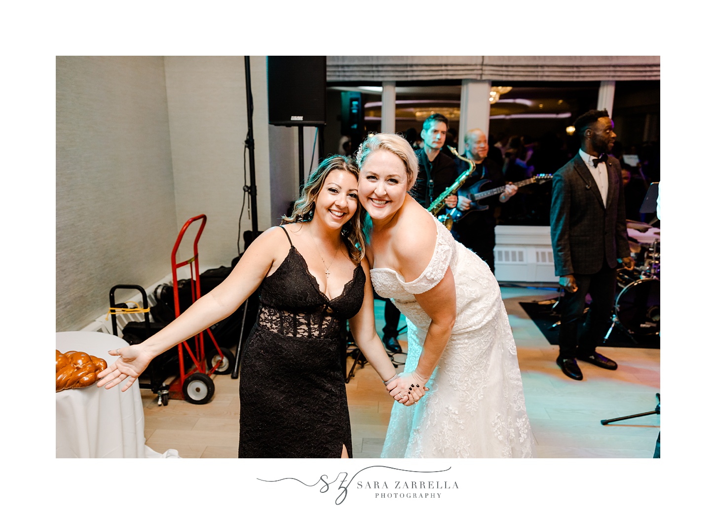 bride smiles with bridesmaid in black gown during north Kingstown RI wedding reception