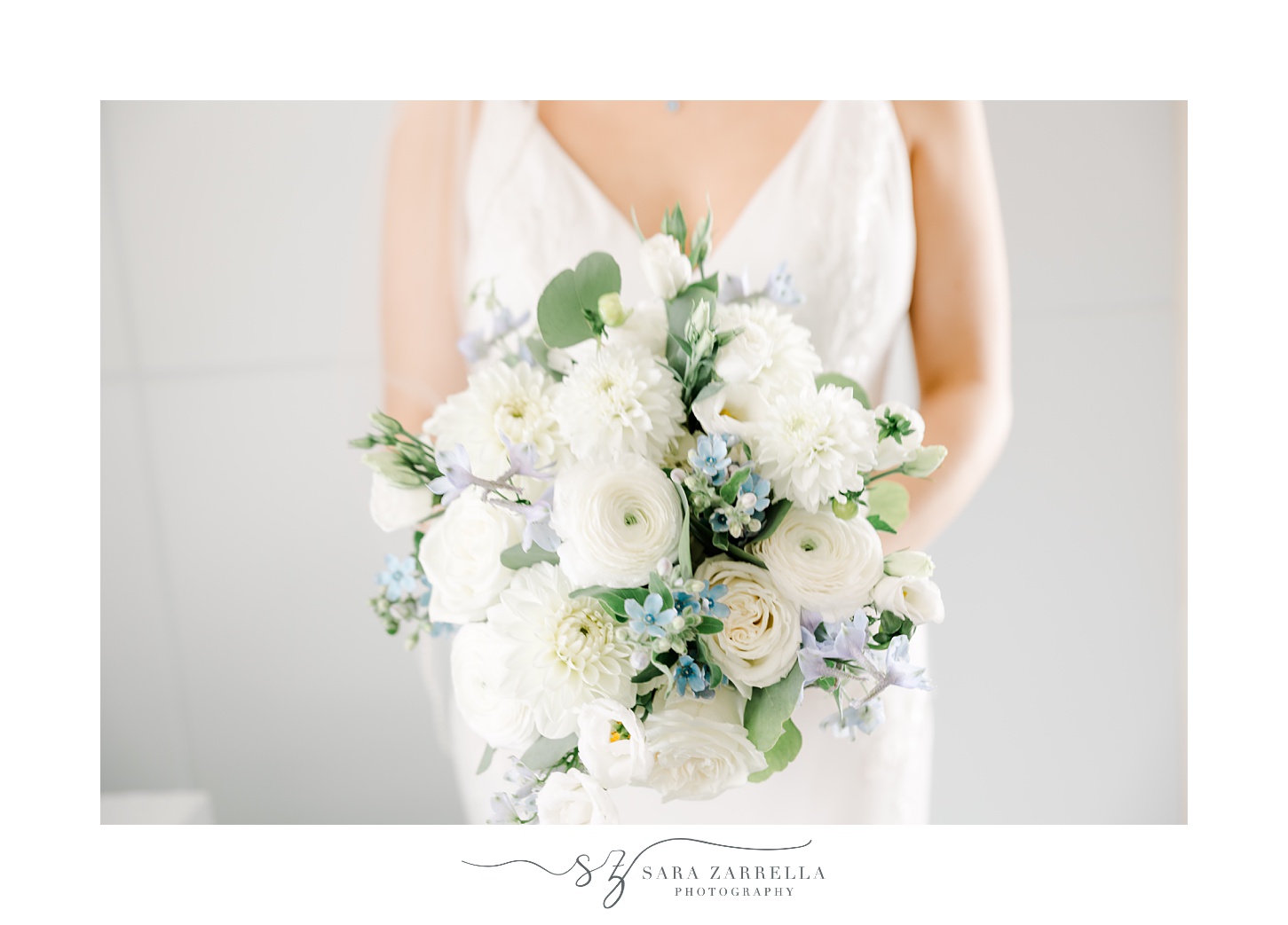bride holds bouquet of white and blue flowers in Rhode Island venue