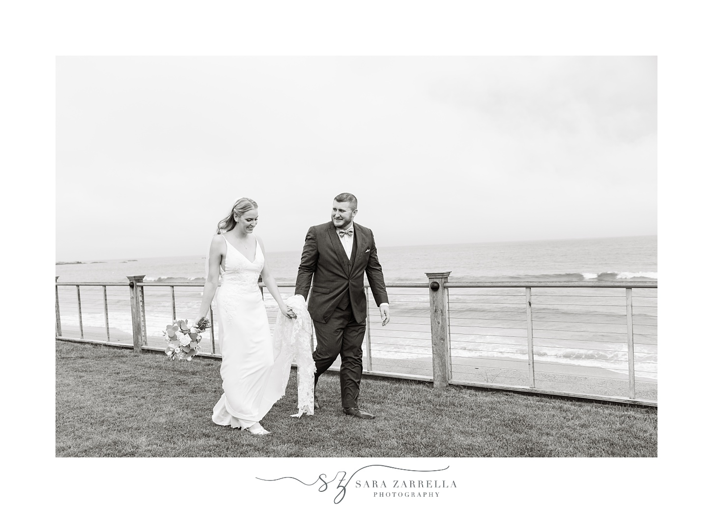 black and white photo of bride and groom walking on lawn at the Dunes Club