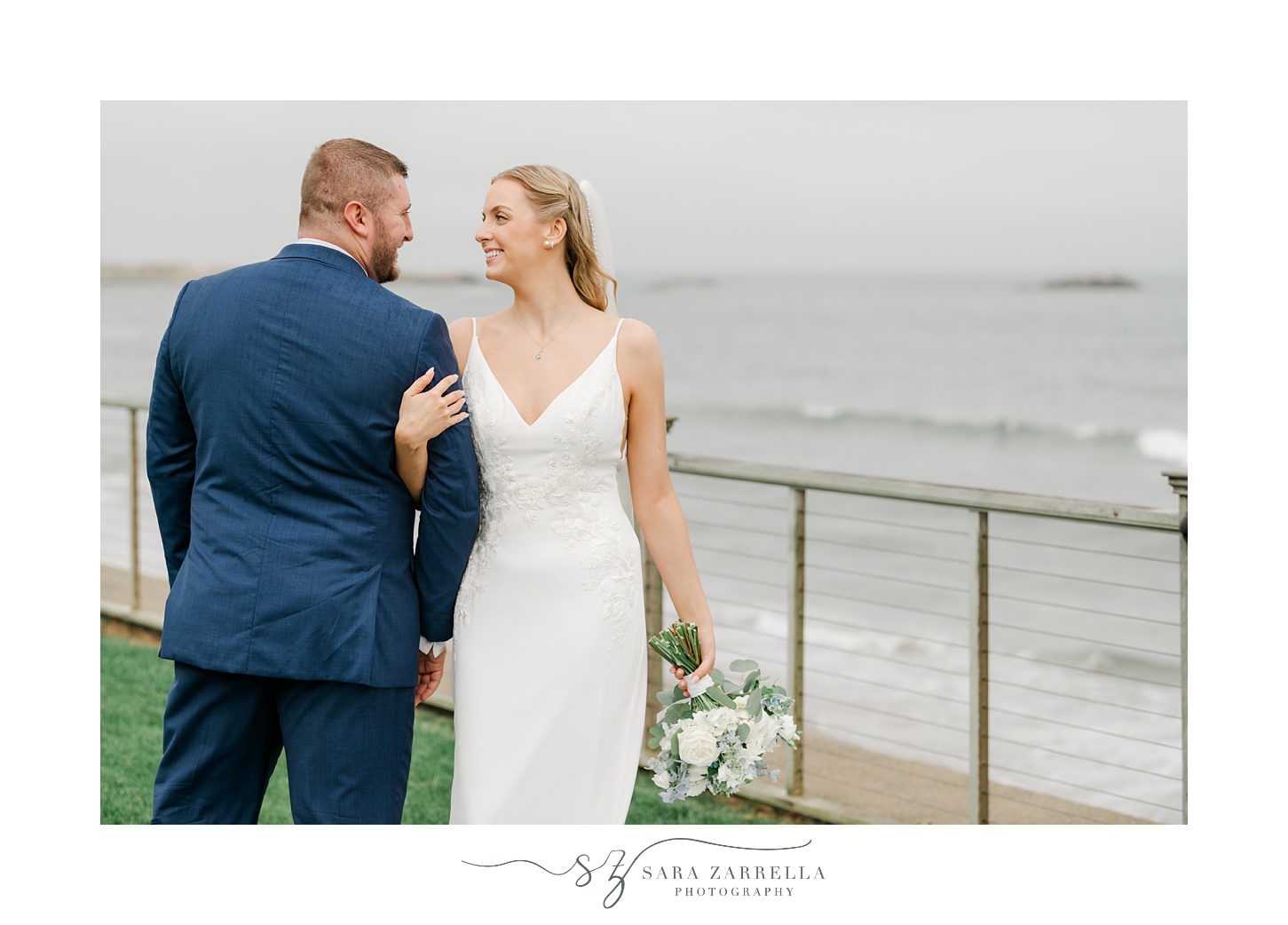 bride holds groom's arm looking at him over her shoulder