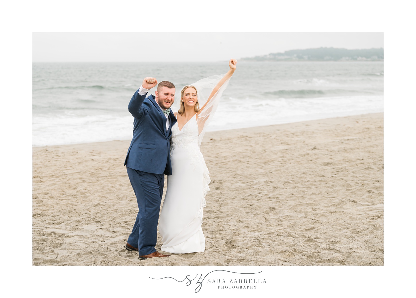 newlyweds cheer on the beach in front of Narragansett Bay