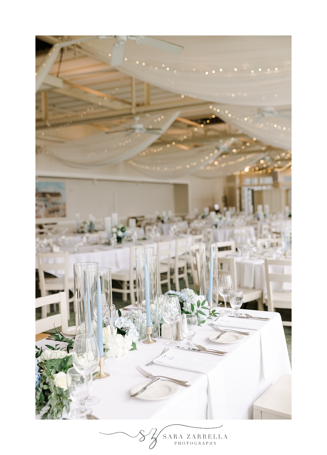 wedding reception tables with blue taper candles and blue and white hydrangeas