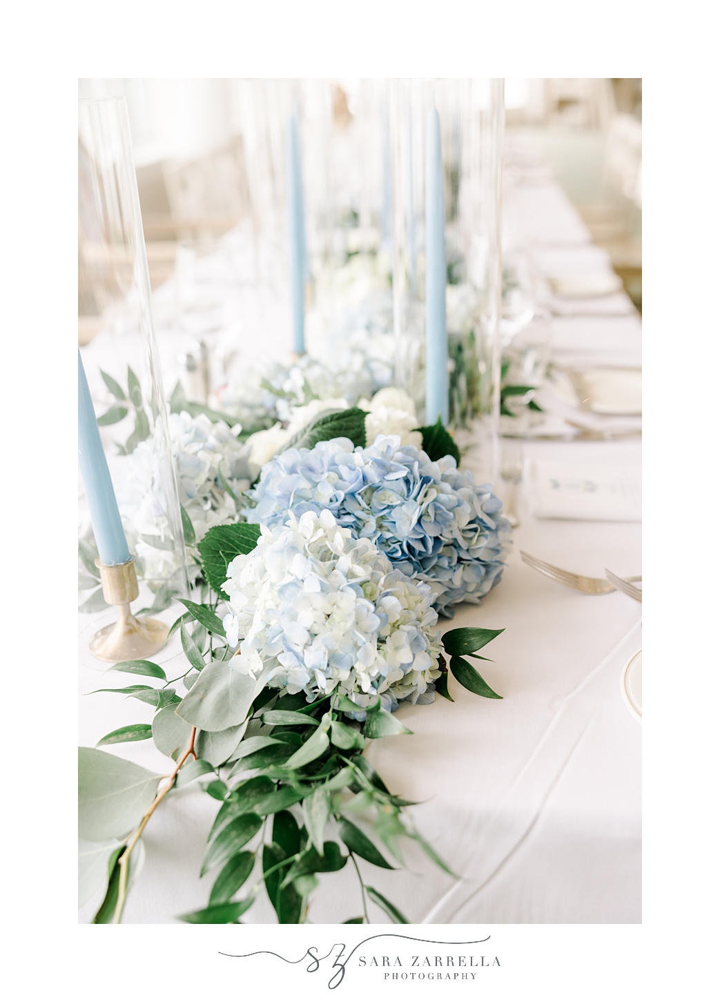 wedding reception with blue taper candles and white and blue hydrangeas