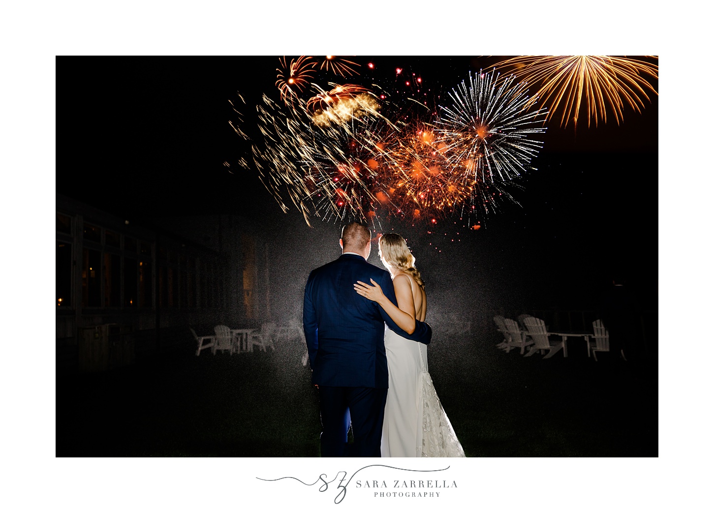 bride and groom hug watching fireworks outside the Dunes Club