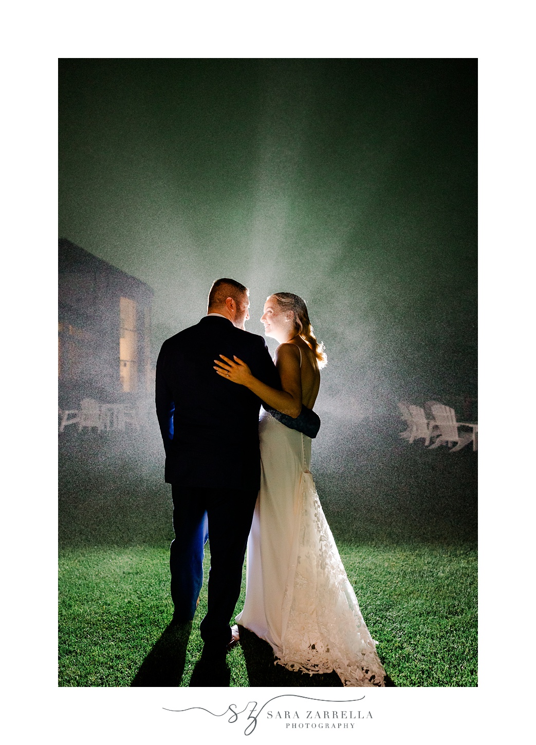 bride and groom hug with light behind them in Narragansett RI
