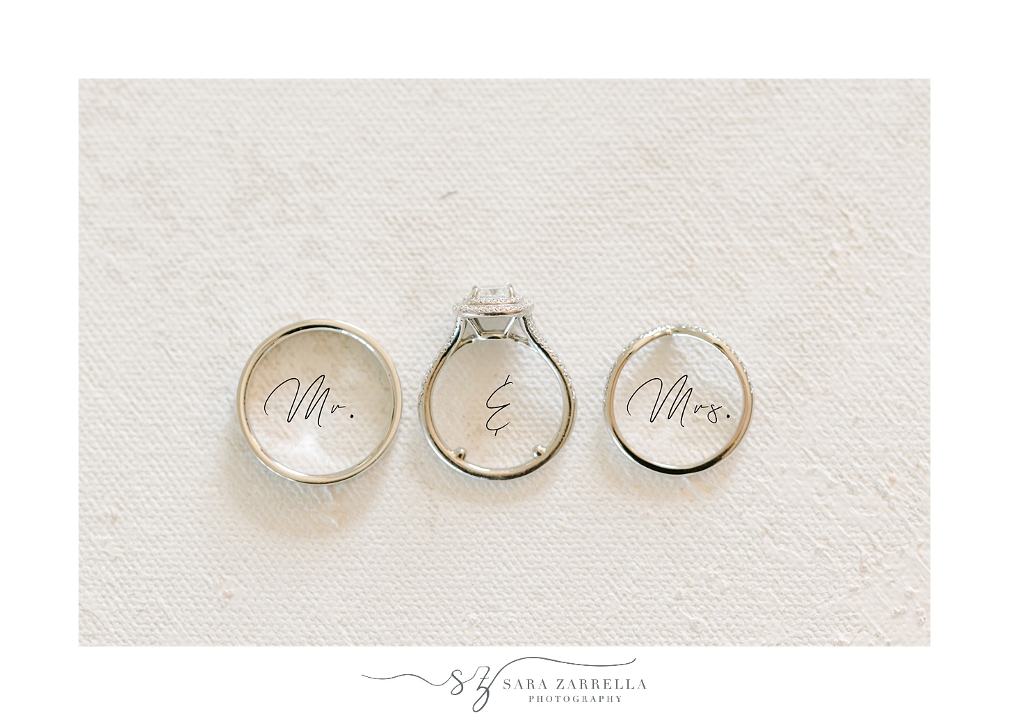 three silver wedding bands rest over Mr and Mrs script