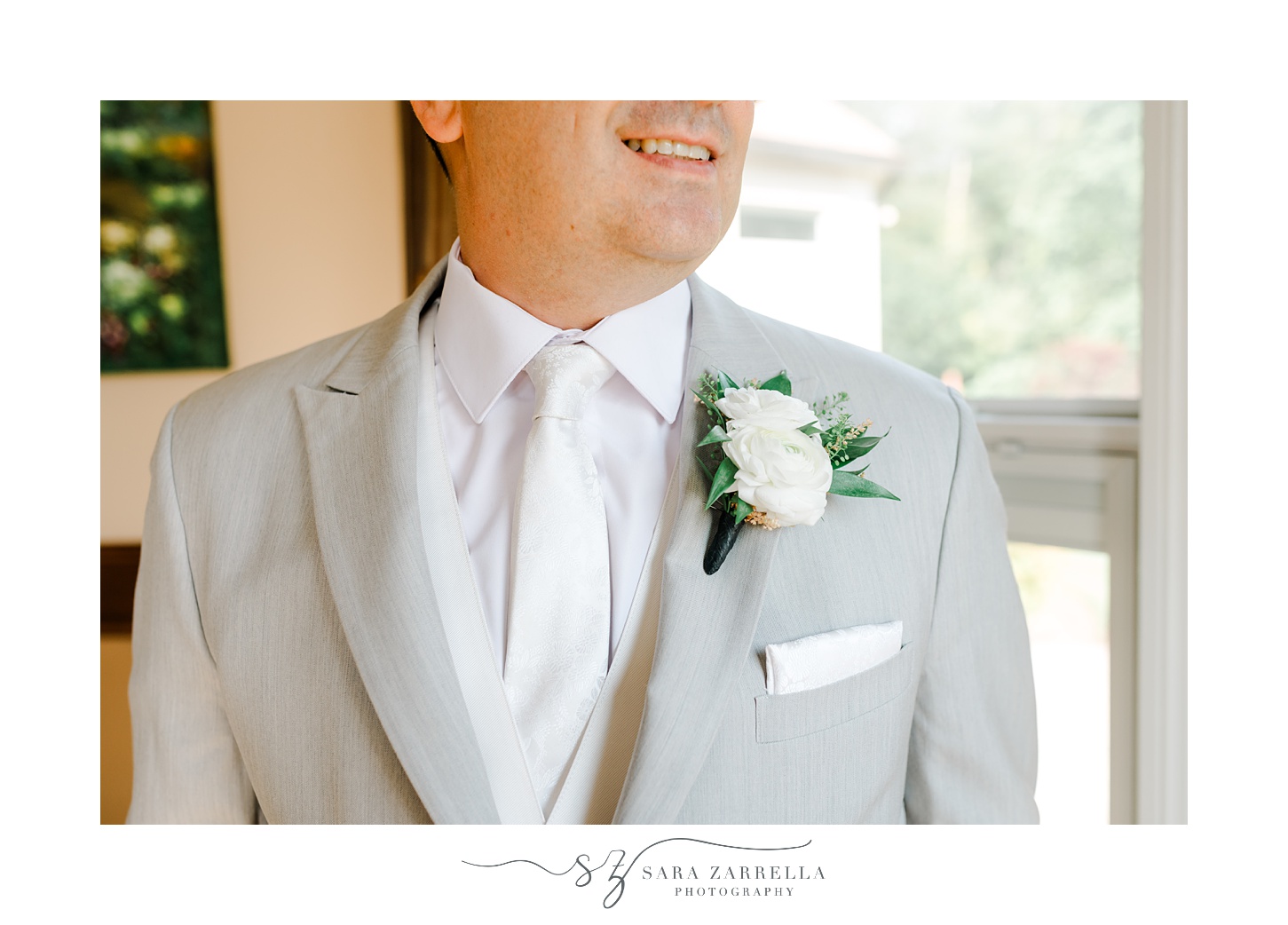 groom looks to the side showing off white boutonnière