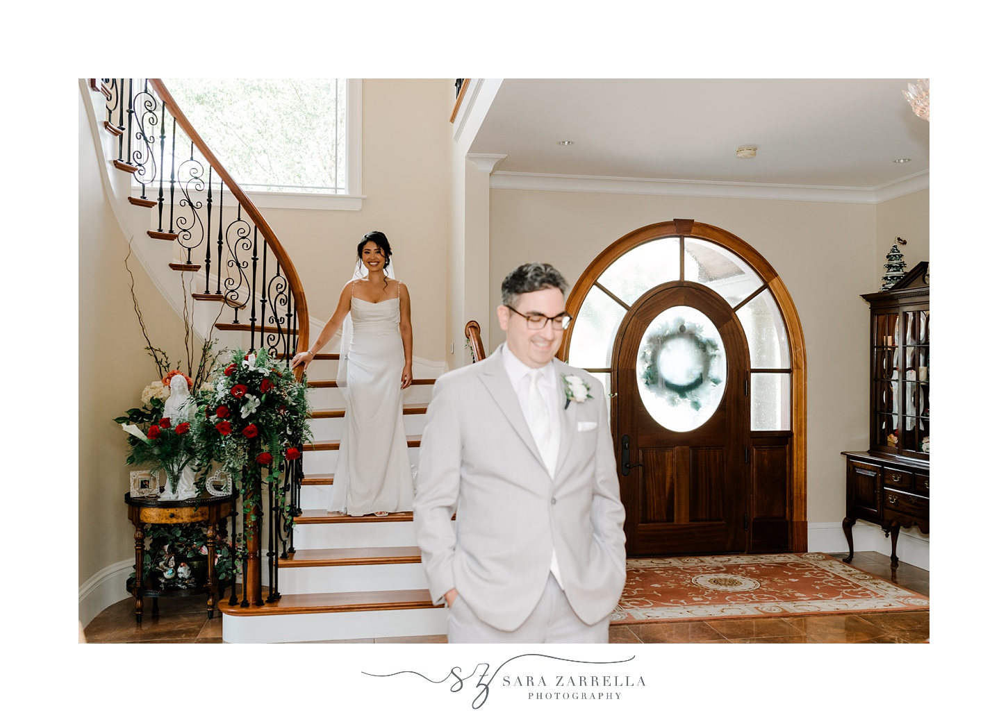 bride approaches groom for first look inside foyer of Cranston home