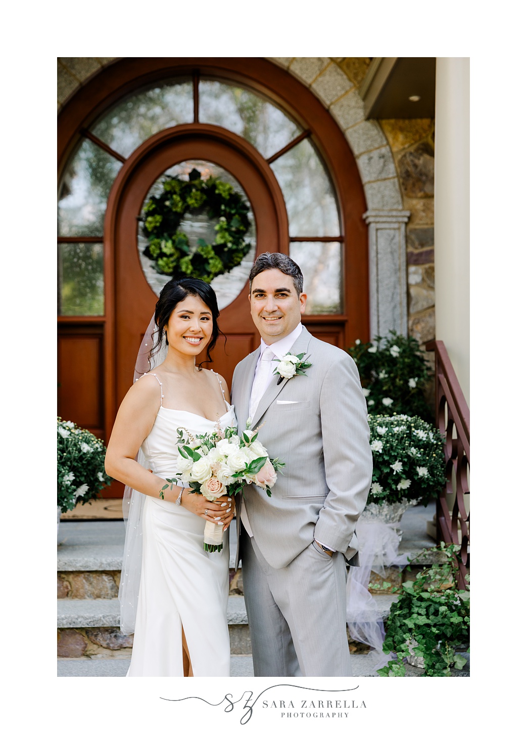 bride and groom pose outside front door of Cranston RI home
