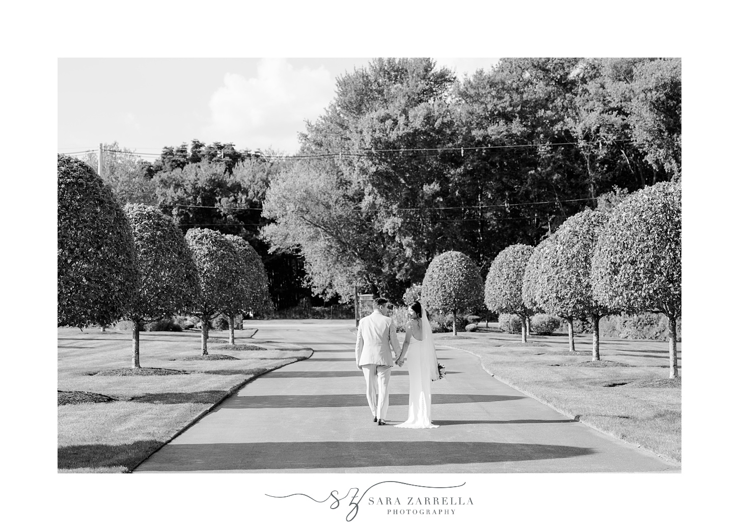 bride and groom walk down driveway of Cranston home