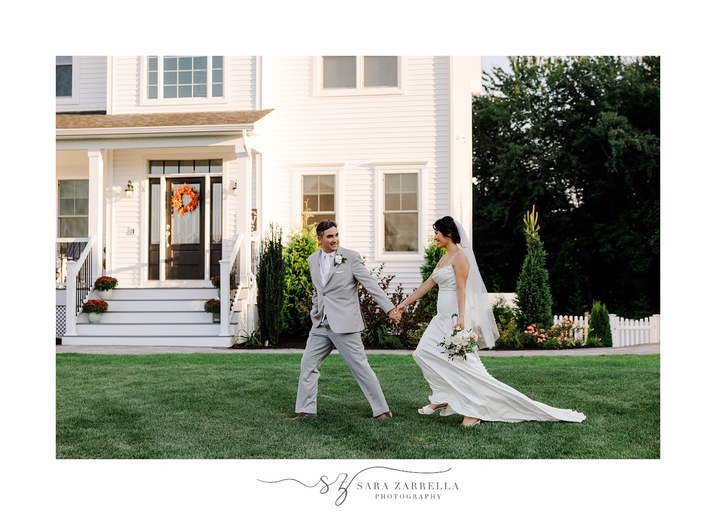 groom leads bride across the lawn of Cranston RI home