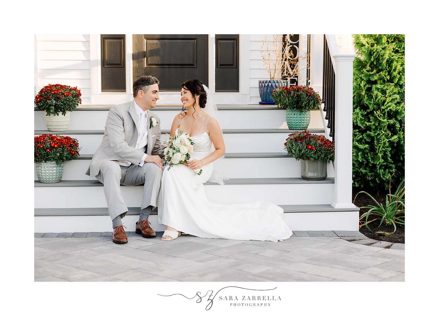 bride and groom sit talking on steps of of Cranston RI home