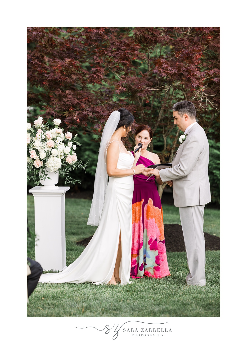 bride and groom hold hands during backyard wedding ceremony in Cranston RI