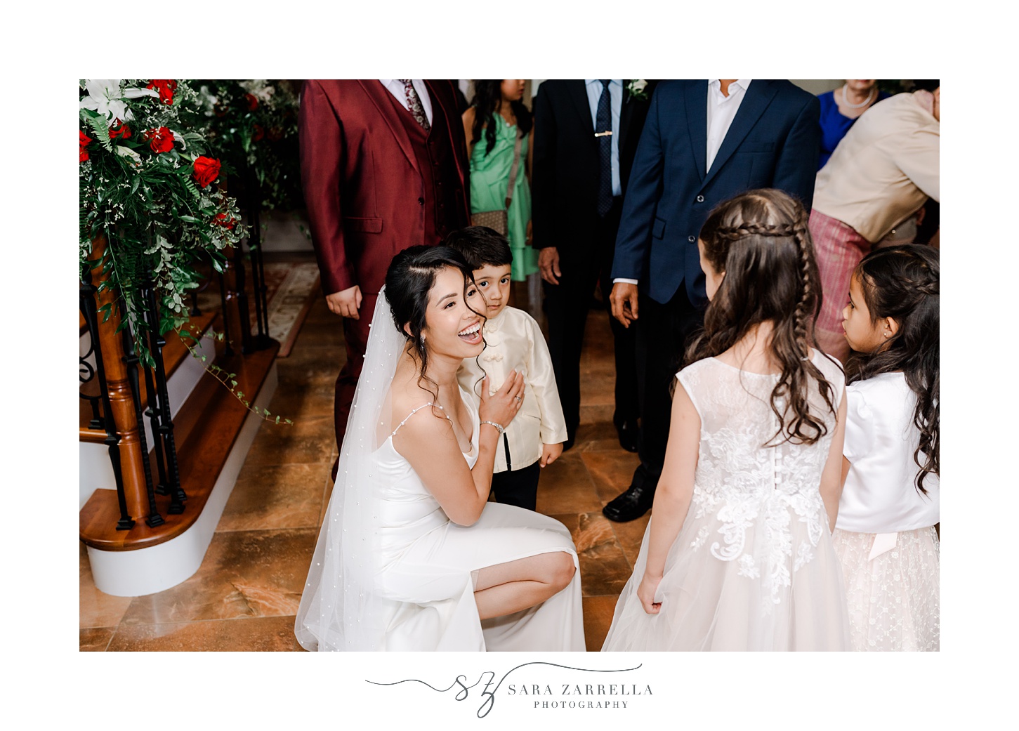 bride kneels hugging young boy during wedding day