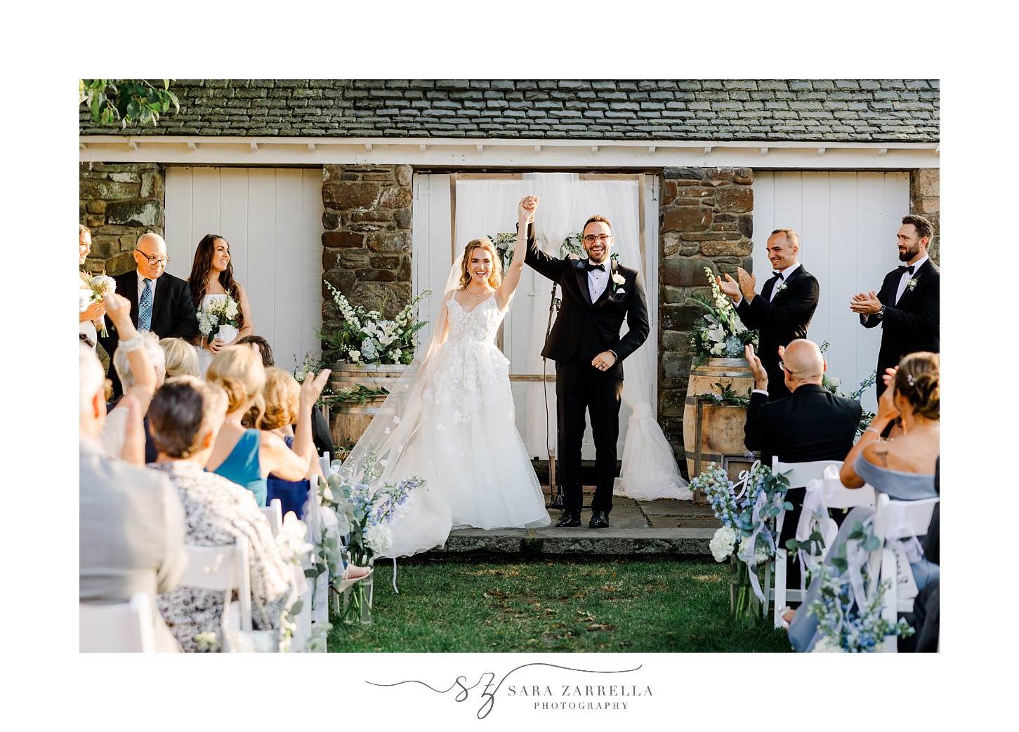 bride and groom hold hands cheering leaving wedding ceremony in the gardens at Shepard's Run