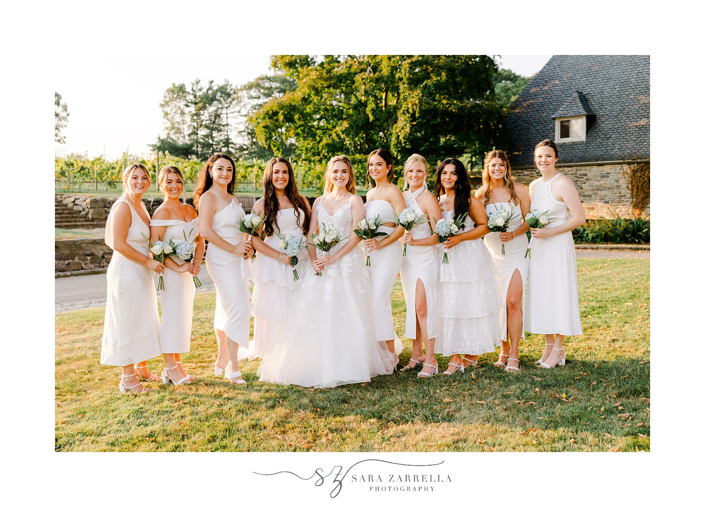 bride poses with bridesmaids in ivory gowns on lawn at Shepard's Run