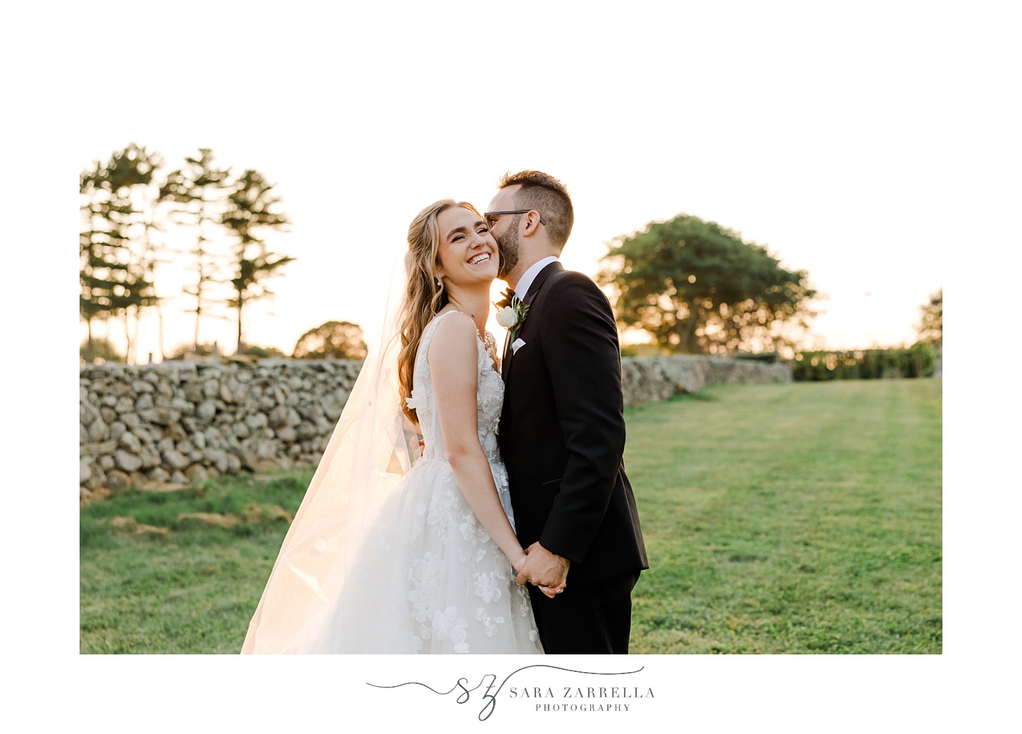 groom leans to kiss bride's cheek by stone wall at Shepard's Run