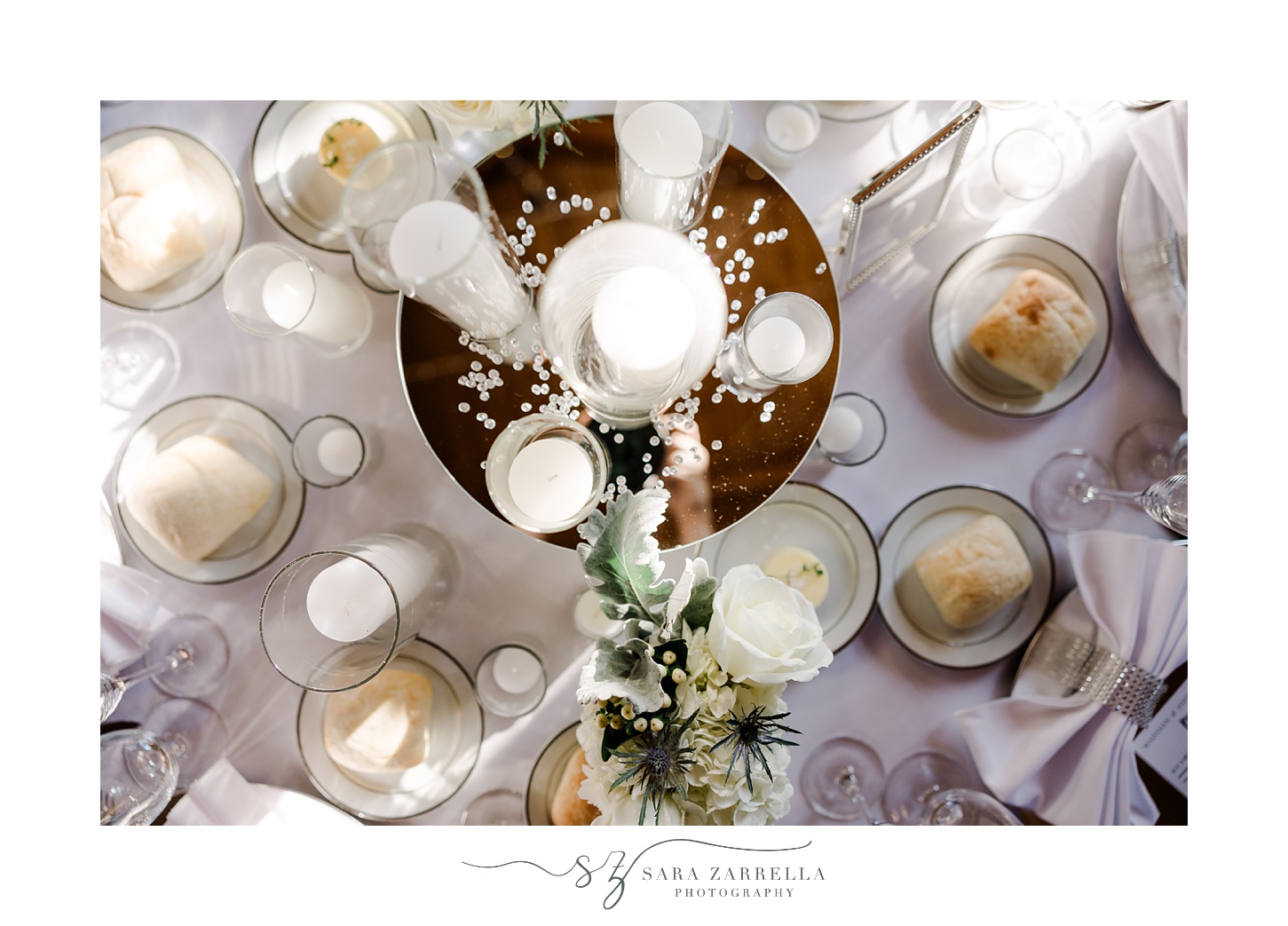 overhead view of reception table with white candles and white roses