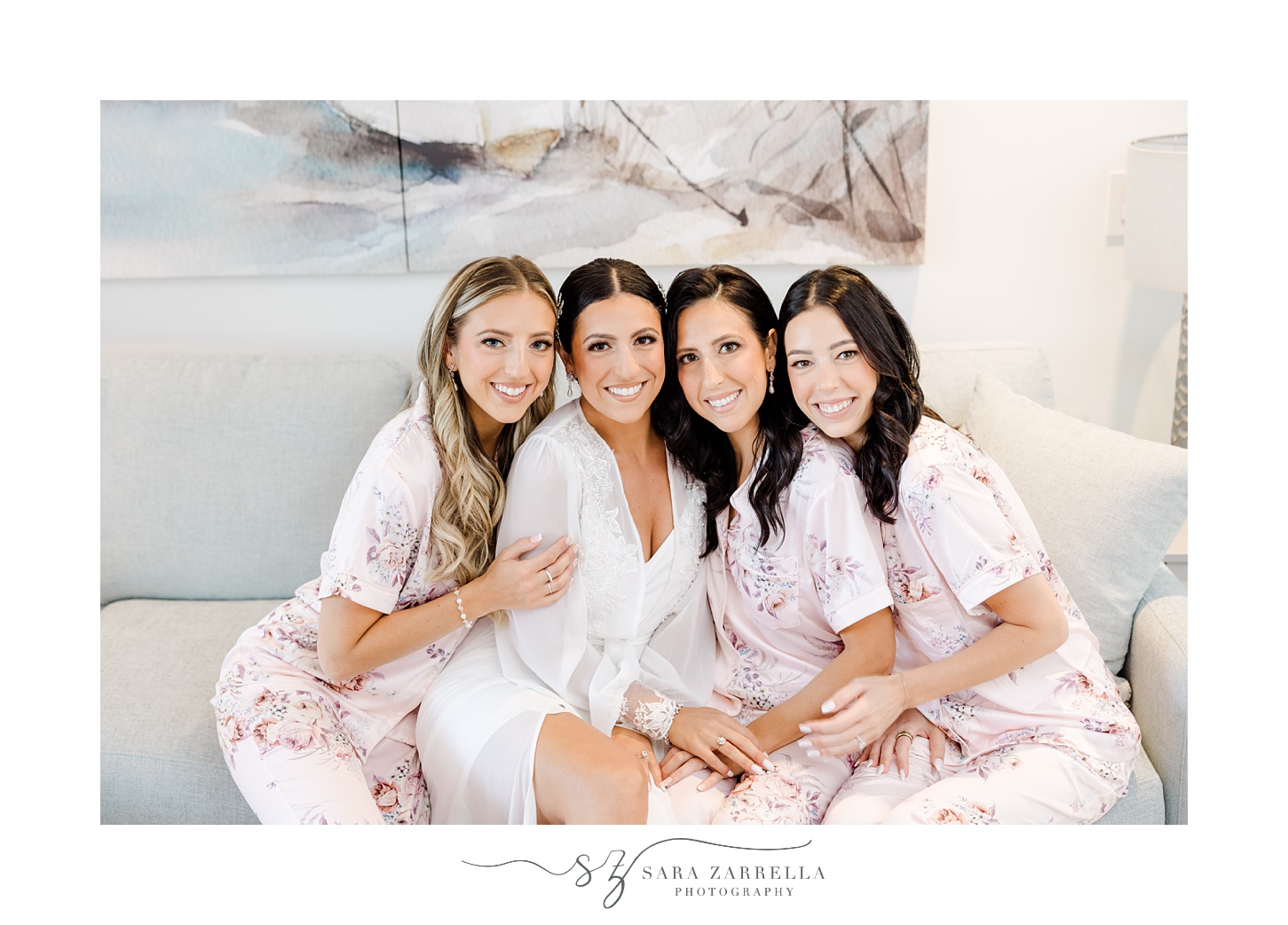 bride sits with bridesmaids in pink floral robes inside Glen Manor House suite