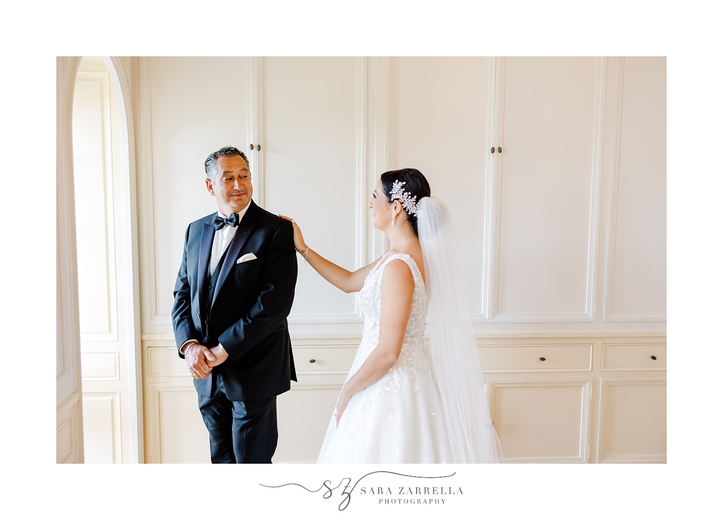 bride reaches out to touch dad's shoulder during first look