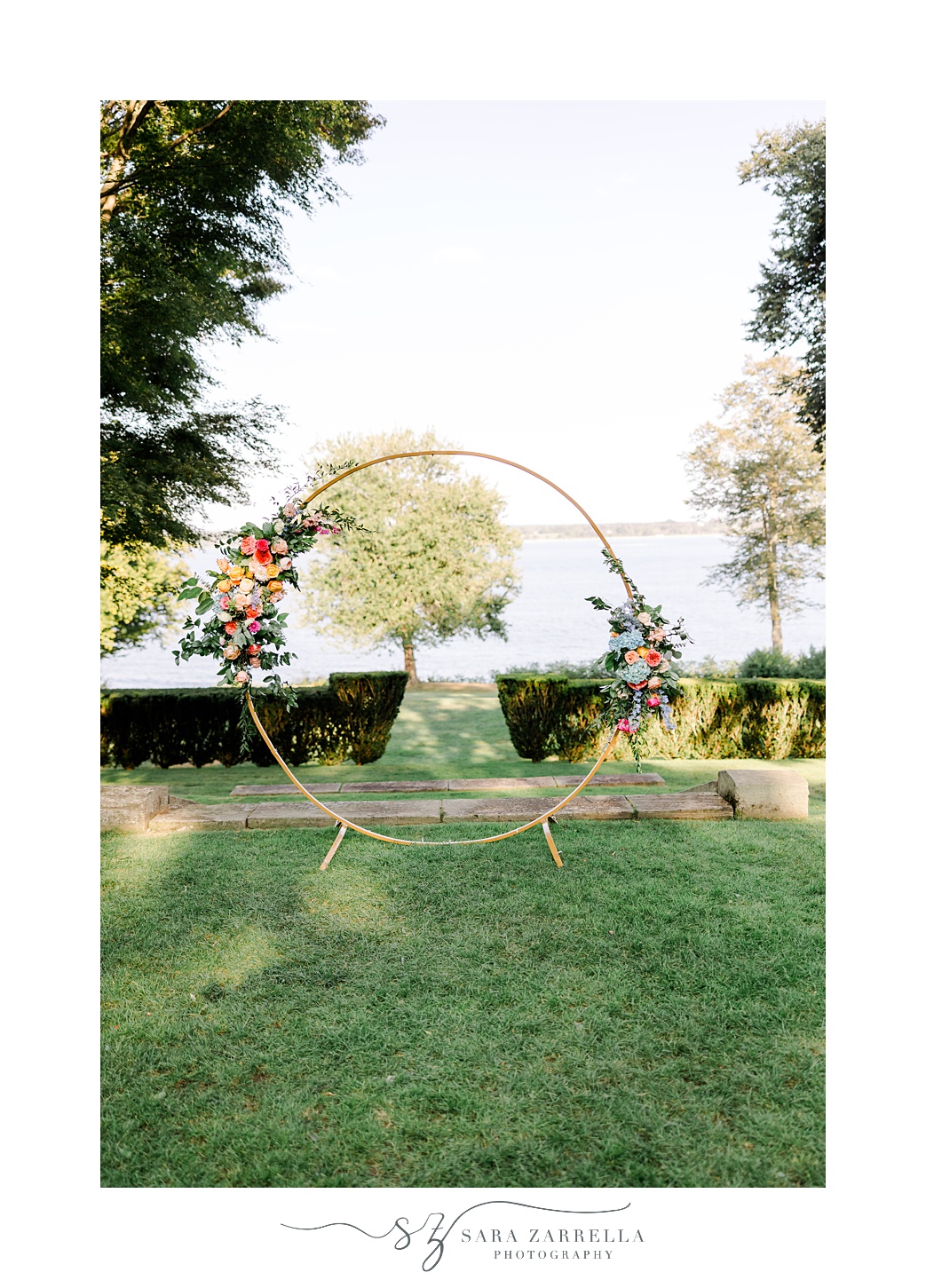 wedding ceremony site with gold circular arbor with flower sprays