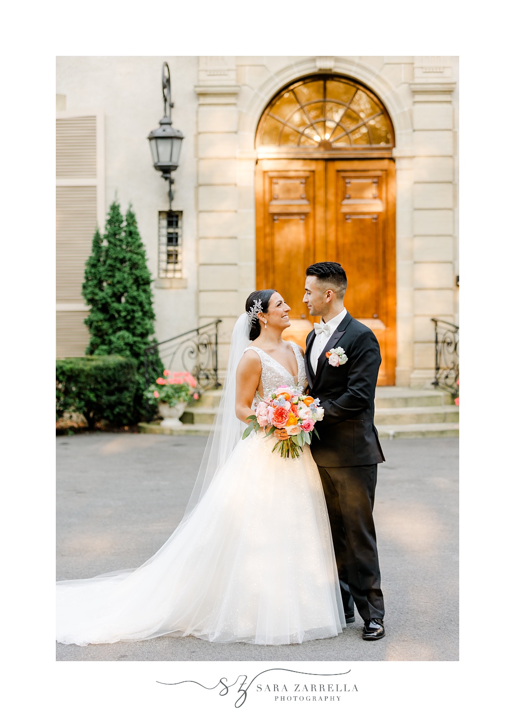 bride and groom smile hugging in front of the building at Glen Manor House