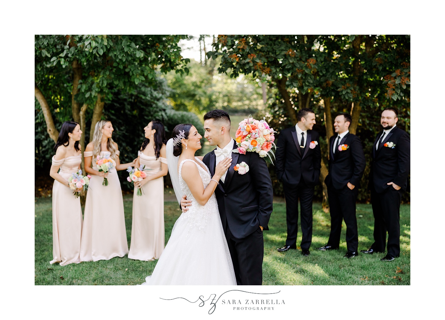 bride and groom kiss n front of wedding party on lawn at Glen Manor House
