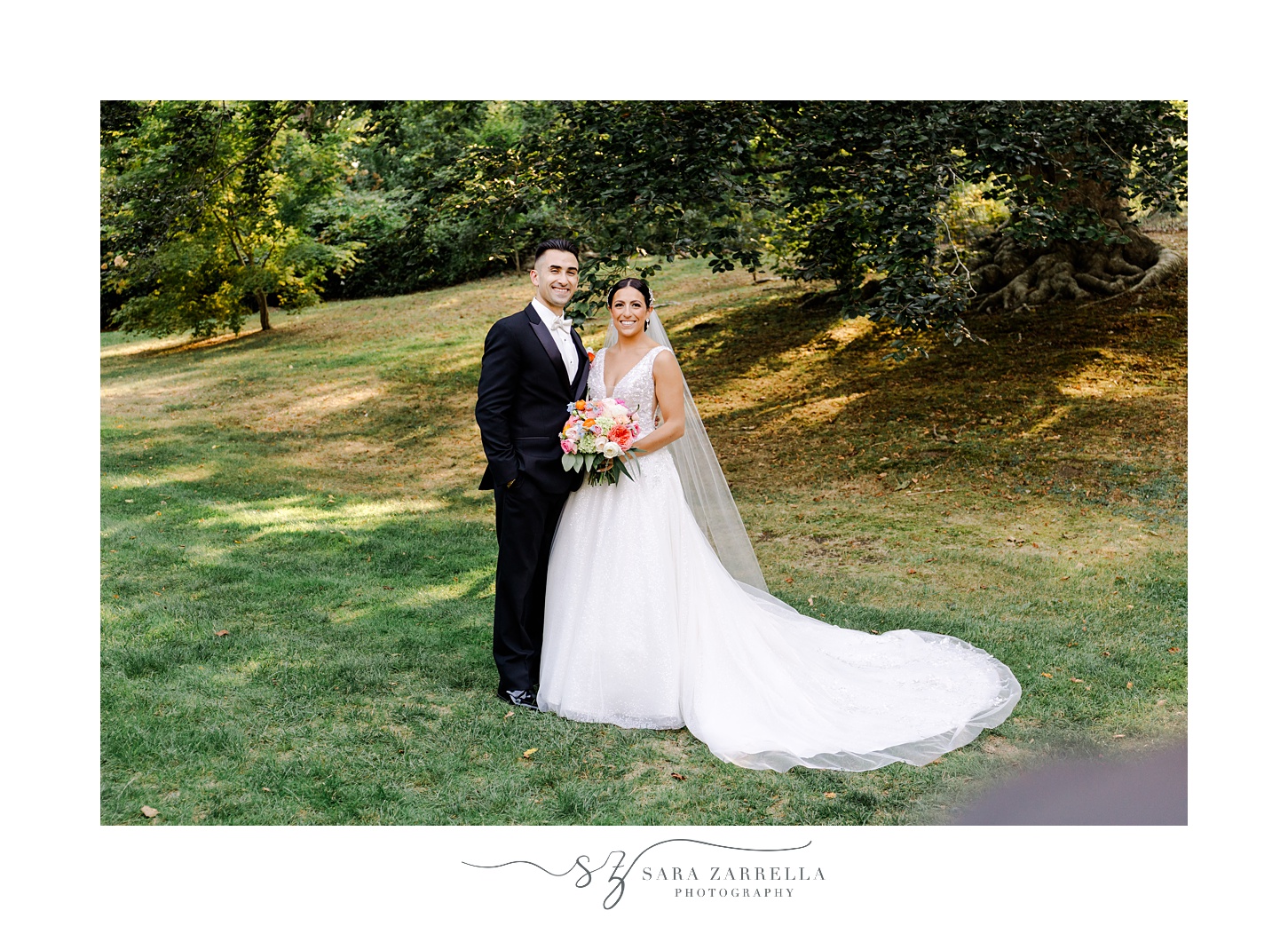 bride and groom smile hugging next to each other on the lawn