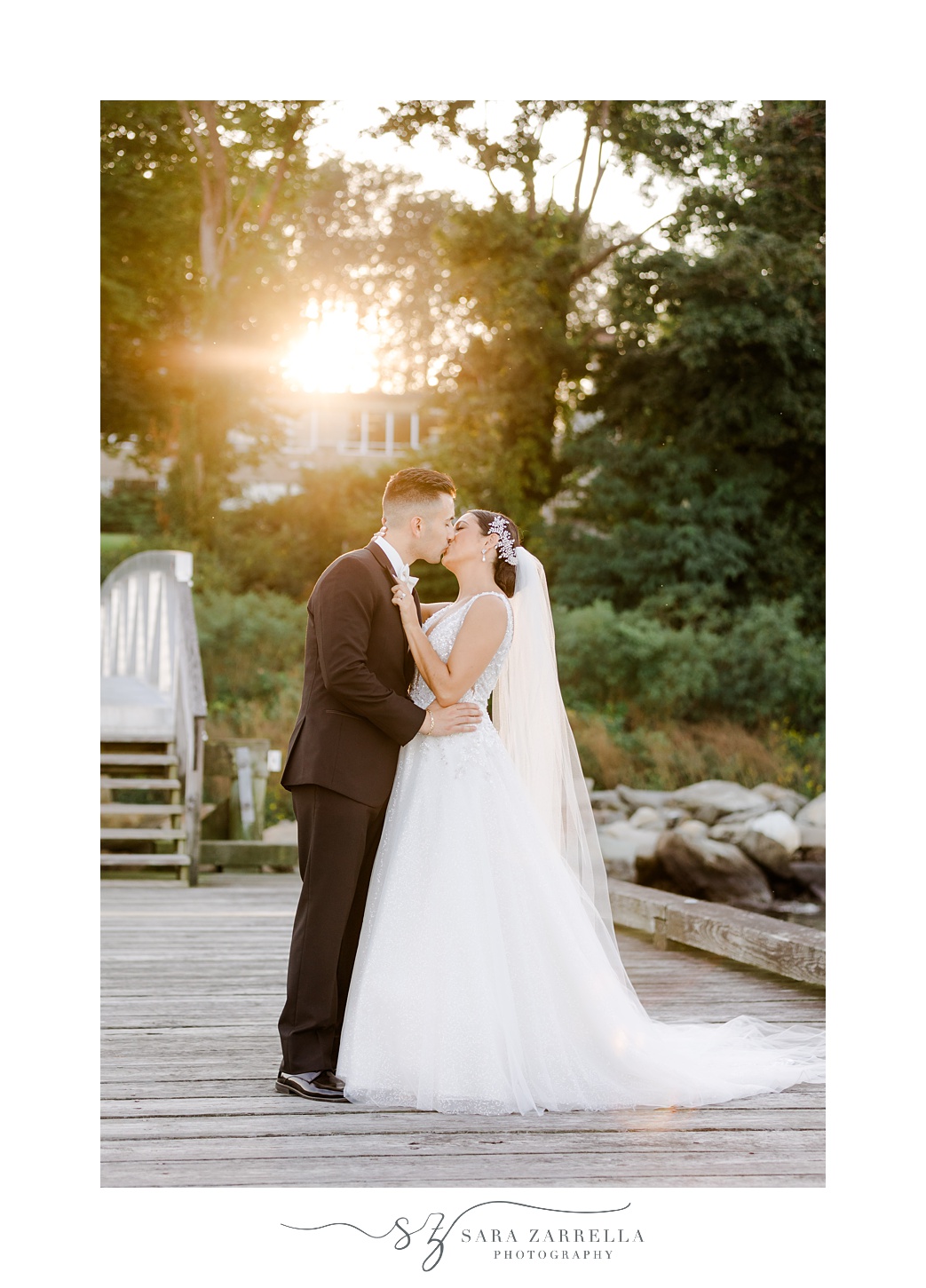 bride and groom kiss on wooden dock outside Glen Manor House