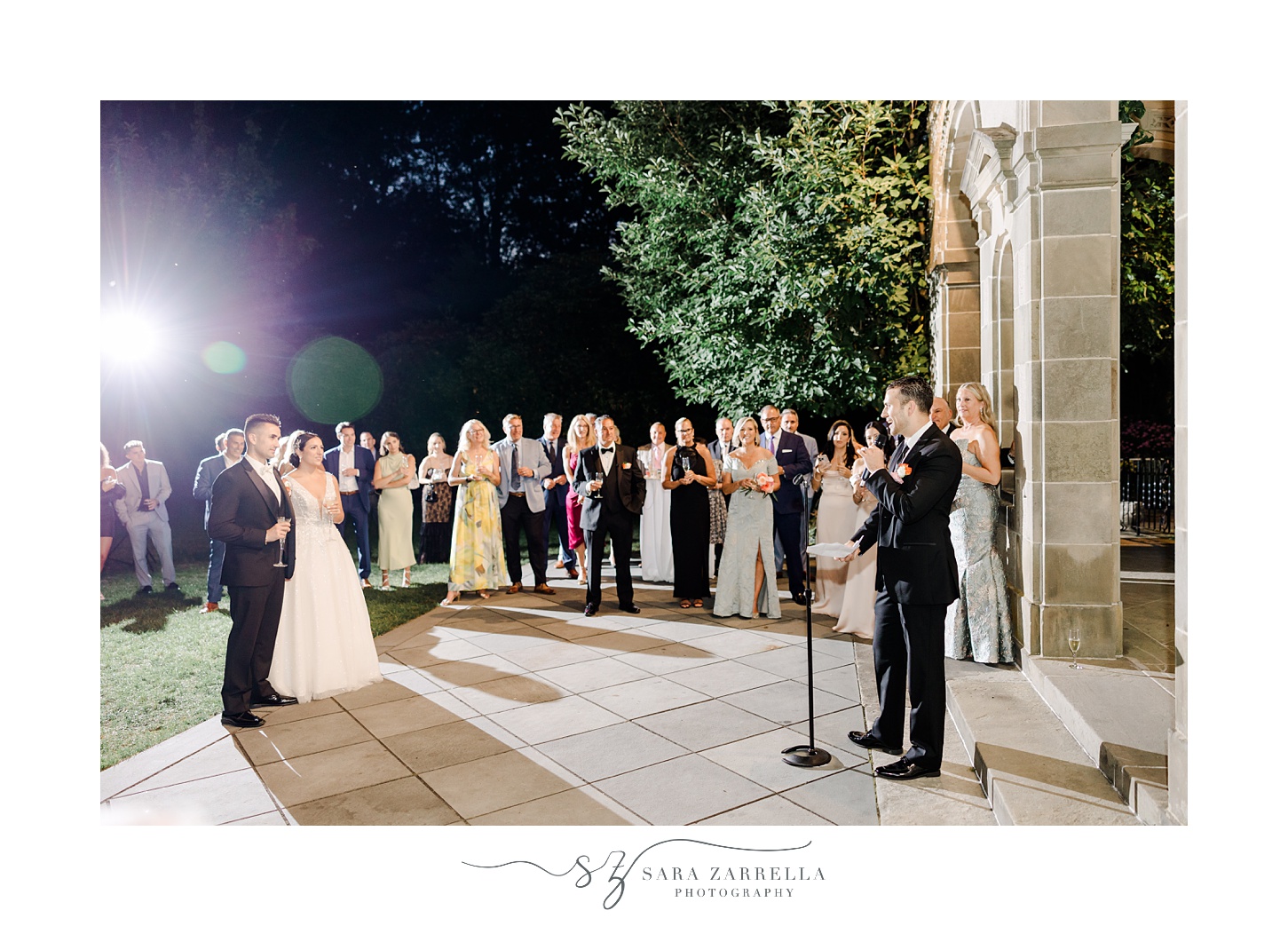 man gives speech to bride and groom on patio of Rhode Island wedding venue