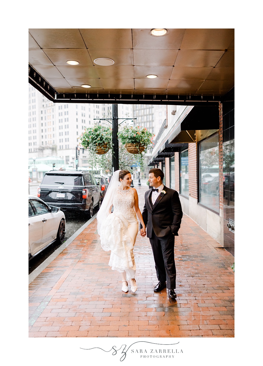 bride and groom hold hands walking outside the Graduate Providence