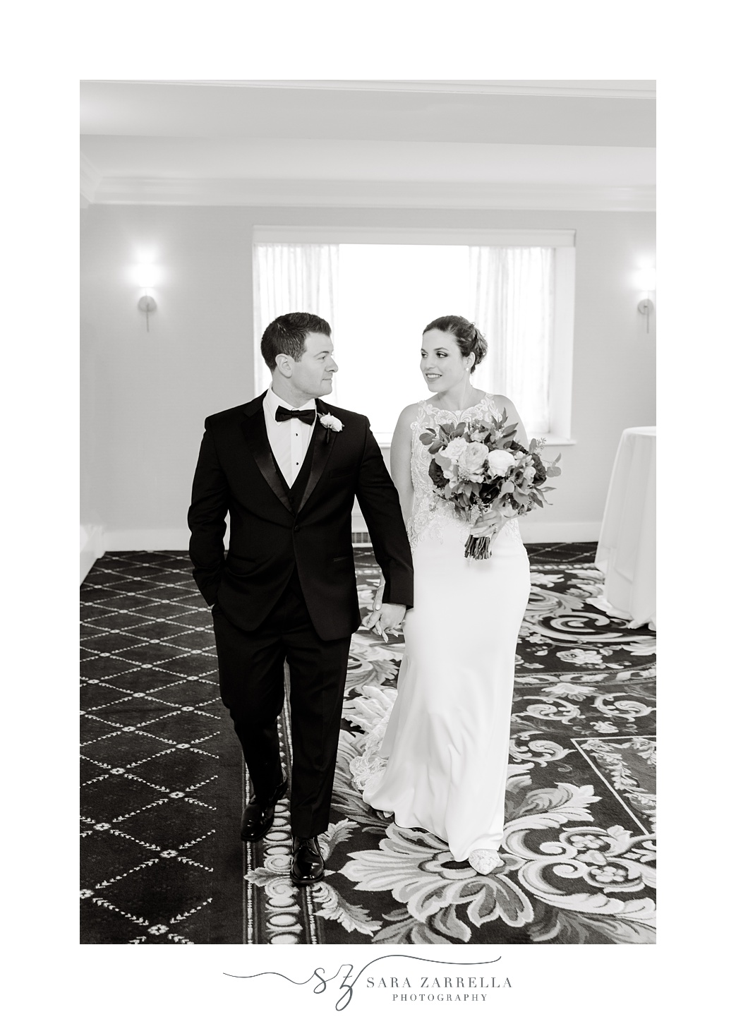 bride and groom hold hands walking through hallway at the Graduate Providence