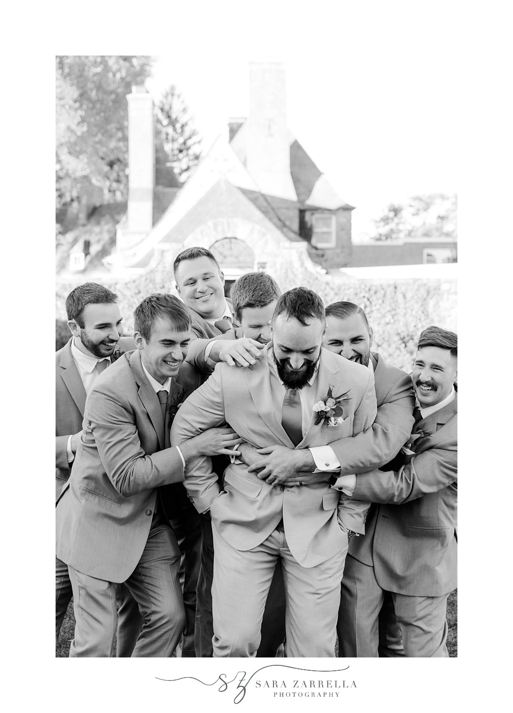 groomsmen hug groom on lawn at Shepard's Run