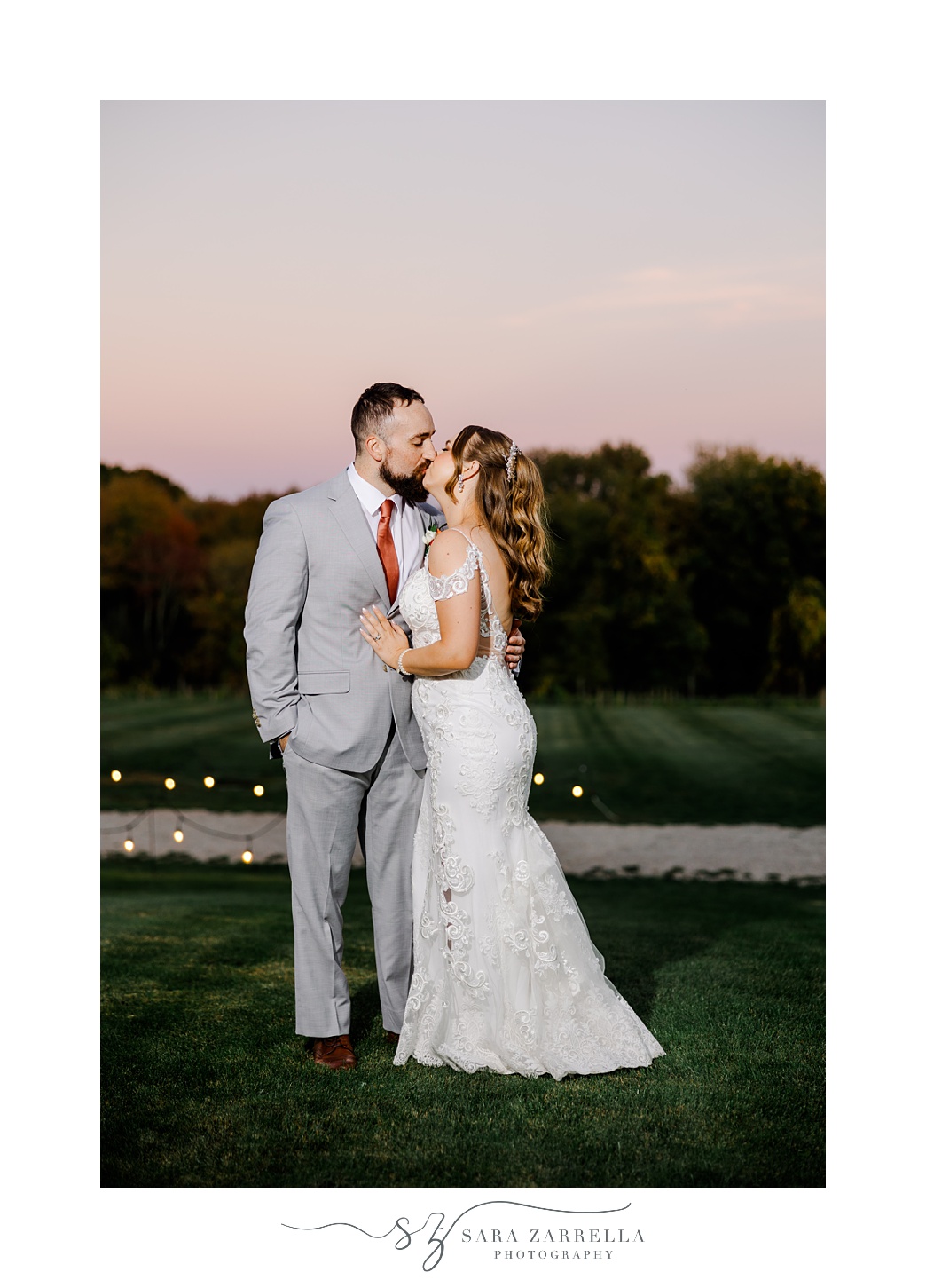 bride and groom hug on lawn outside Shepard's Run at sunset